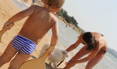 Sardinien mit Hund, Kinder mit Hund am Strand.