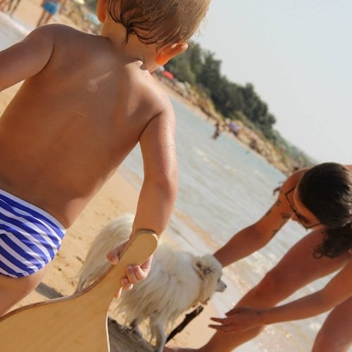 Mutter mit Kind und Hund am Strand auf Sardinien.